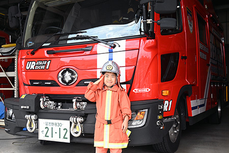写真：消防広場の子ども用防火衣・感染防止衣着装体験の様子
