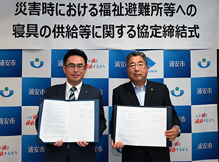 写真：協定書を手に並ぶ市長と株式会社フクシン代表取締役社長